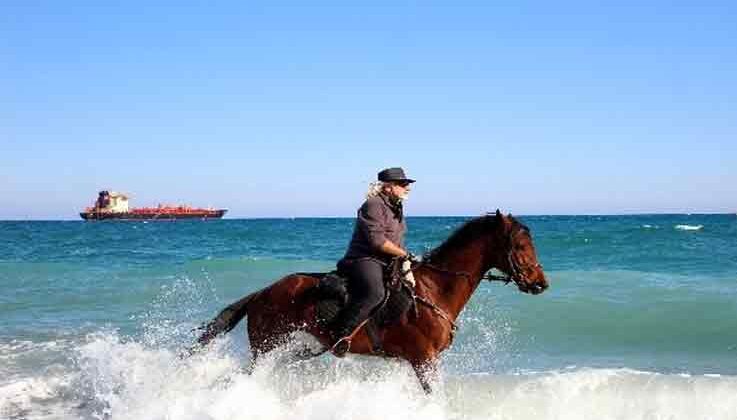 Kovboy şapkasını takıp Antalya sokaklarında at koşturuyor, gören bir daha bakıyor