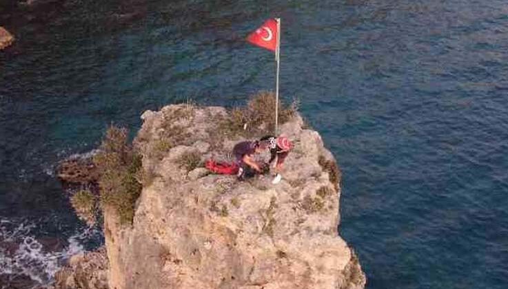 Bayrak sevgisiyle çıktığı 25 metrelik kayalıklarda mahsur kaldı