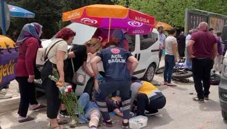 Kazada acı içinde yerde yatan kadına hemcinsinden plaj şemsiyeli koruma