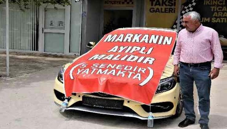 Aldığı lüks aracı işyerinin önüne koyup, üzerine “Markanın ayıplı malıdır, 5 yıldır yatmakta” yazdı