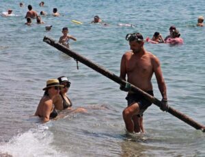 Ekmeğini denizin dibinden çıkartıyor, elindekileri gören tatilciler şaşkına dönüyor