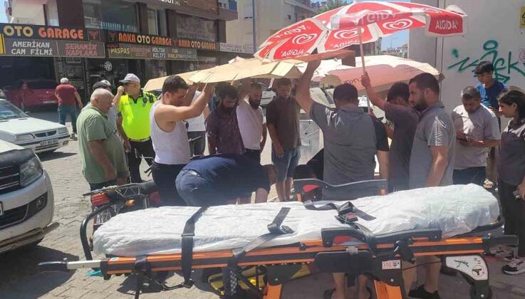Sağlık ekiplerini beklerken yaralıyı güneşten korumak için seferber oldular